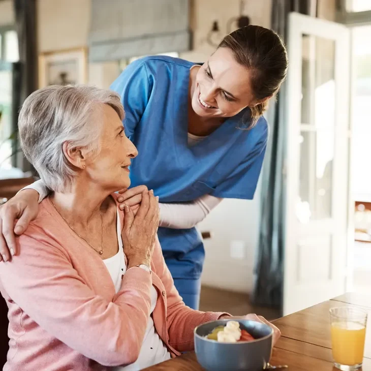 A young man caring for an elderly woman at home.